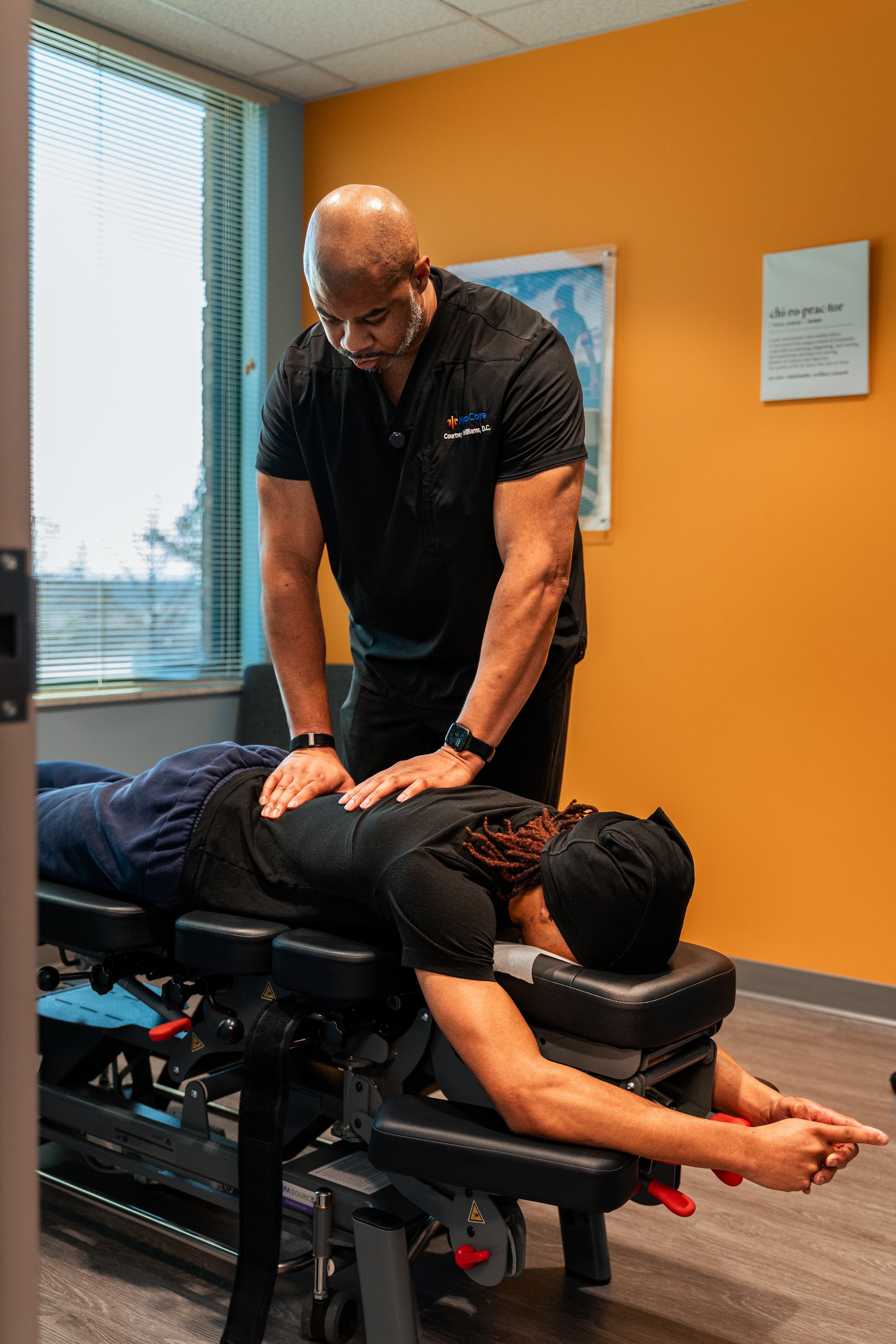 Dr. Williams performing a spinal adjustment on a patient in the CJW Chiropractic Solutions treatment room